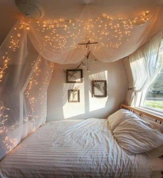 a white bedroom with fabrics and lights around the bed