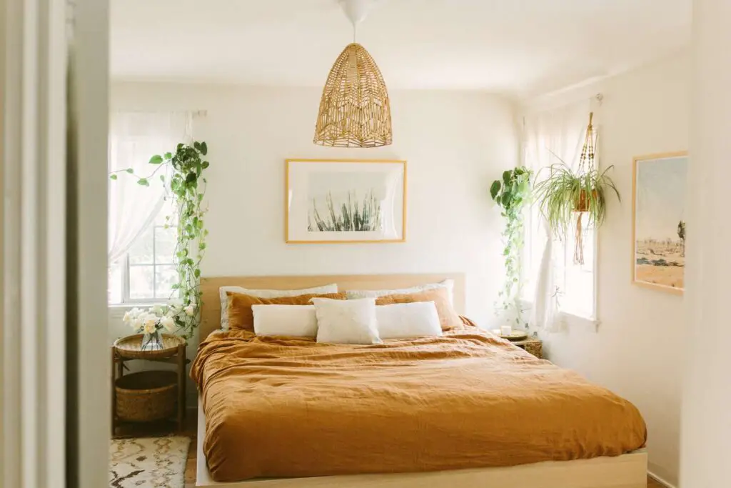 white bohemian bedroom with mustard color fabric and plants