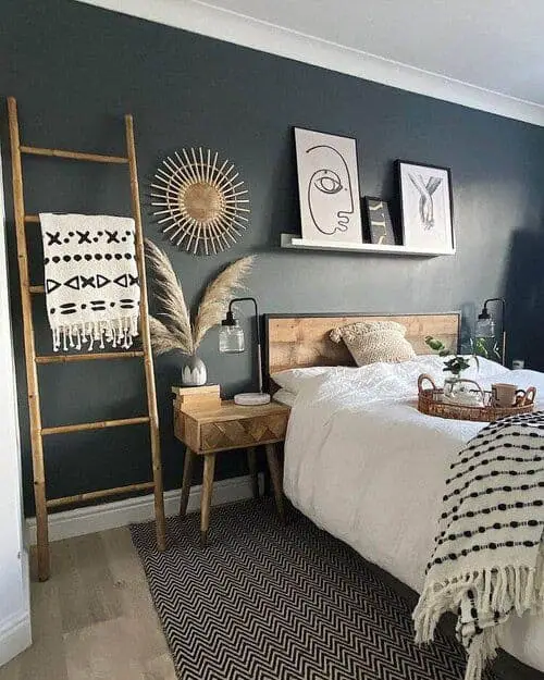 dark grey boho bedroom with wooden furniture and artwork