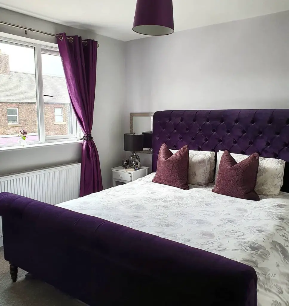 white bedroom with aubergine bed frame
