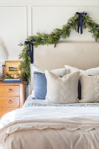 blue and gold Christmas decor in bedroom with a green garland