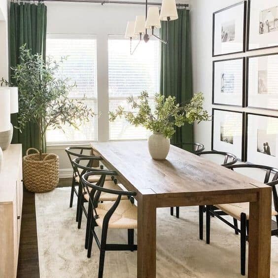 farmhouse dining room with wooden table, plants and green curtains